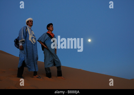 Bedouins in the sand desert with the horizon the blue sky and the full moon Merzouga Morocco Africa Stock Photo