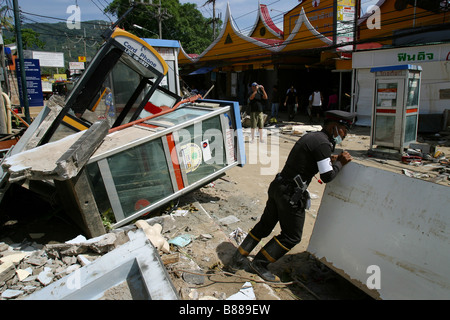 A Thai policeman moves debris after the December 26, 2004 tsunami at Patong Beach, Phuket Island, Thailand. Stock Photo