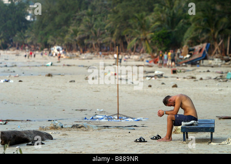 A man sits alone on Patong Beach, Phuket Island, Thailand the day after the December 26, 2004 tsunami. Stock Photo