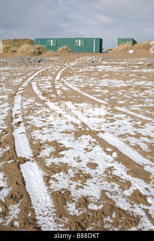 snow in ruts created by tires on Newton beach after rare snowfall Stock Photo
