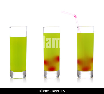 A three glasses of fresh kiwi juice with cherries and straw reflected on white background Stock Photo