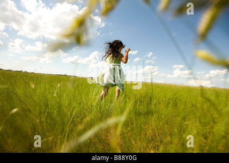 Girl running through a grassy field in North Dakota Stock Photo