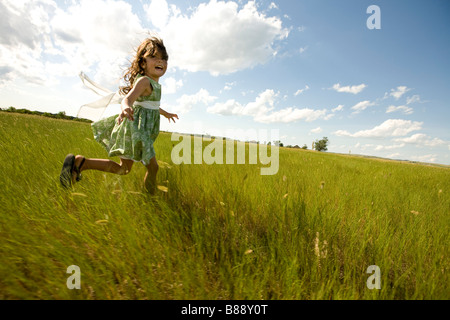 Girl running through a grassy field in North Dakota Stock Photo