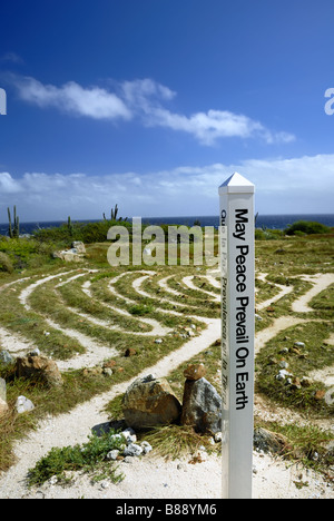 A multi lingual marker with the message "May Peace Prevail on Earth" stands at the Peace Labyrinth on the island of Aruba. Stock Photo