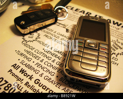 Screen saver, Mobile phone, set of car keys and an old advert. Stock Photo