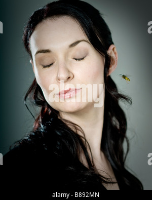 Portrait of young woman being pestered by a wasp. Stock Photo