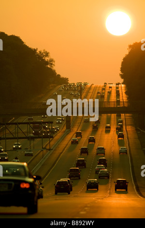 sunset over the road with cars Stock Photo - Alamy