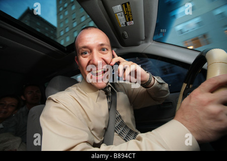 Businessman driving in car and talking on cell phone Stock Photo