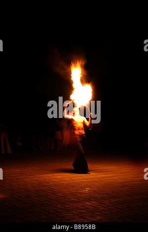 fire eater performance on a street and audience on a dark background Stock Photo