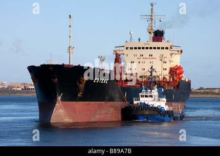 Tugboat pushing cargo ship in Foynes Harbour, County Limerick Ireland Stock Photo
