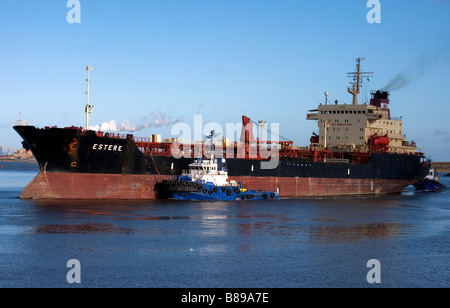 Tugboat pushing cargo ship in Foynes Harbour, County Limerick Ireland Stock Photo