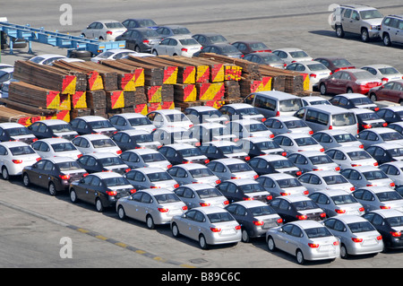 Bahrain looking down close up on dockside storage of imported new cars and large piles of timber awaiting distribution Stock Photo