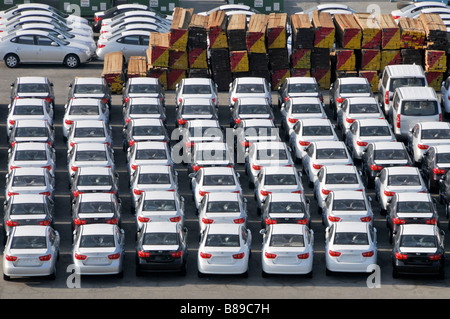 Bahrain looking down close up on dockside storage of imported new cars and large piles of timber awaiting distribution Stock Photo