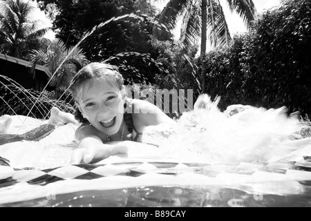 child playing on water slide on grass Stock Photo