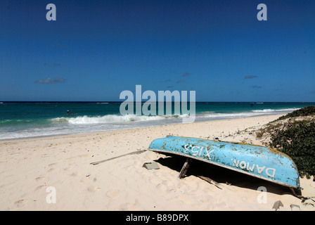 A blue wooden boat lying at a wonderful idyllic Silver sand beach at Barbados Caribbean Stock Photo