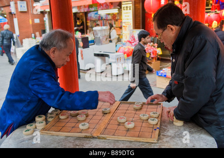 Two men playing a game of chinese checkers in Chinatown London UK Stock Photo