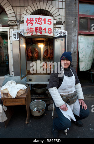 Woman street vendor selling roast chickens and ducks in Beijing China 2009 Stock Photo