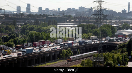 Heavy traffic stacks up on the M6 near Birmingham as passengers on a nearby train ease past it without any delay Stock Photo