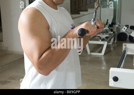 Man doing triceps cable pull down exercise in the gym Stock Photo