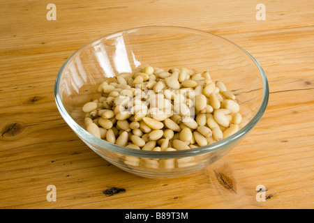 Pine nuts in a glass bowl on a pine table. Stock Photo