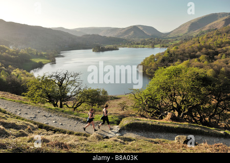 Joggers jogging running on Loughrigg Fell above Grasmere valley and lake in the Lake District National Park, Cumbria, England. Stock Photo