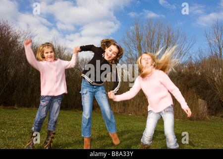 Three jumping girls 6 9 and 11 years old Stock Photo