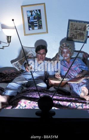 Goofy  Couple Watching TV in Bed Stock Photo