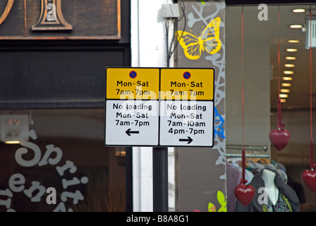 british yellow and white sign showing parking restrictions,  on chiswick high road, west london, england Stock Photo