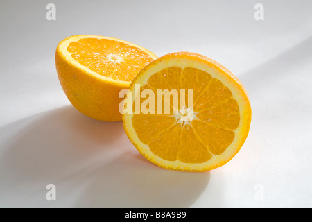 STILL LIFE FRUIT VEGETABLE Two halves of a navel orange sliced evenly Stock Photo