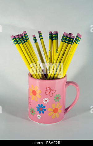 A cup or mug of Number 2 Ticonderoga lead or graphite yellow pencils and erasers Stock Photo