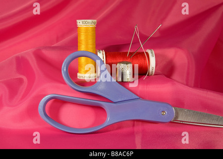 A sewing kit with needle spools of thread a thimble and scissors Stock Photo