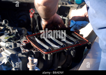 Auto mechanic replacing a plenum gasket on a GM automobile (1995 Buick
