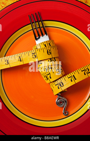 Tape measure wrapped around fork on plate Stock Photo