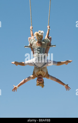 Two female trapeze artists on swing Stock Photo