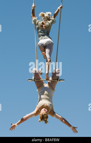 Two female trapeze artists on swing Stock Photo