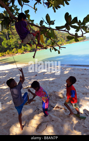 Moken sea gypsy kids enjoy climbing the tree and rope,Koh Surin,Southern Thailand Stock Photo