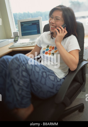 FV3402, zoomphotographics; Asian Woman Curled up Chair Phone, Home fice Stock Photo
