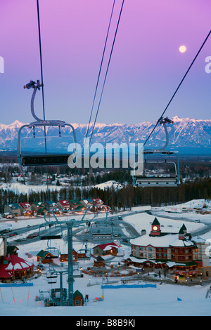 Early evening at Kimberley Alpine Resort from the top of main piste towards village witn moon in sky over Canadian Rockies Stock Photo
