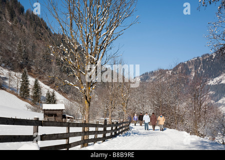 Rauris Rauriser Sonnen Valley Austria People walking on Winterwanderweg cleared trail along Alpine valley with snow in winter Stock Photo