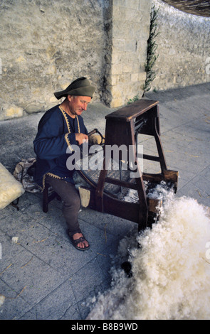 Man Carding Wool on Traditional Carding Machine, Entrevaux Medieval Festival, Alpes-de-Haute Provence, France Stock Photo