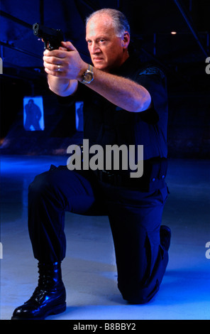 Policeman aiming gun on indoor firing range Stock Photo