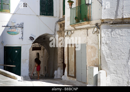 Woman sweeping Ostuni Puglia Italy Stock Photo