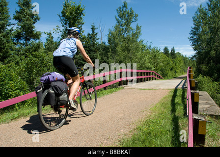 Woman pedals across a bridge Confederation Trail, Prince Edward Island, Canada. Stock Photo