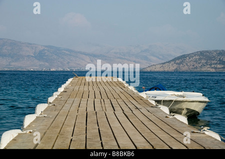 Close-up of jetty lined in white bumper tyres,  perspective leading to sea, Albanian mountains, Agni, Corfu, Kerkyra, Greece, EU Stock Photo