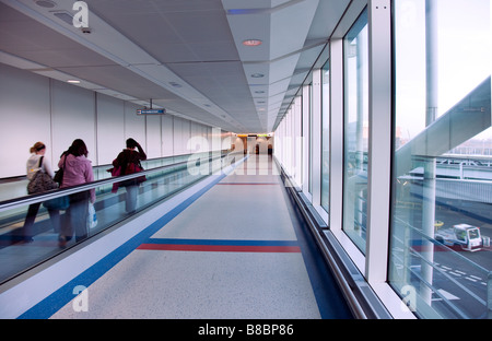 People travelling along an escalator at Gatwick Airport blurred by the movment of travelling at speed along it, Gatwick, England, UK Stock Photo