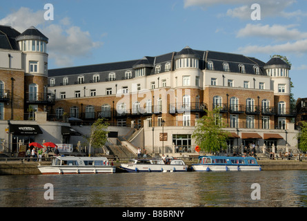 Staines riverfront: Visiting holiday boats and cruisers before riverside cafes and restaurants on the River Thames at Staines Stock Photo