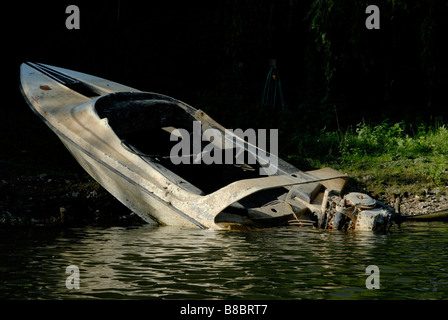 Burnt out speedboat and outboard engine on bank of the River Thames, Staines, Middlesex, England Stock Photo