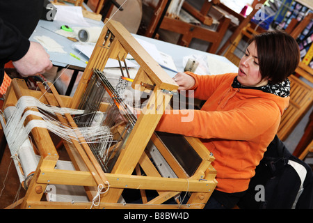 Textiles student learning traditional hand weaving skills in a small ...