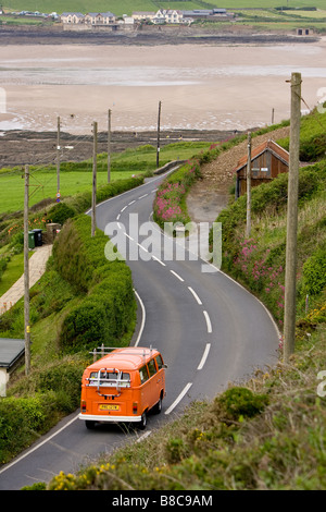 VW camper van driving down croyde road towards surf beach Stock Photo