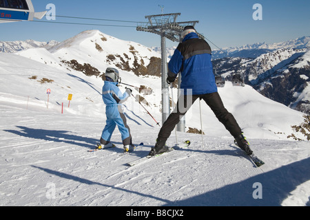 Rauris Austria EU January Man with a young child preparing to ski down the slopes Stock Photo